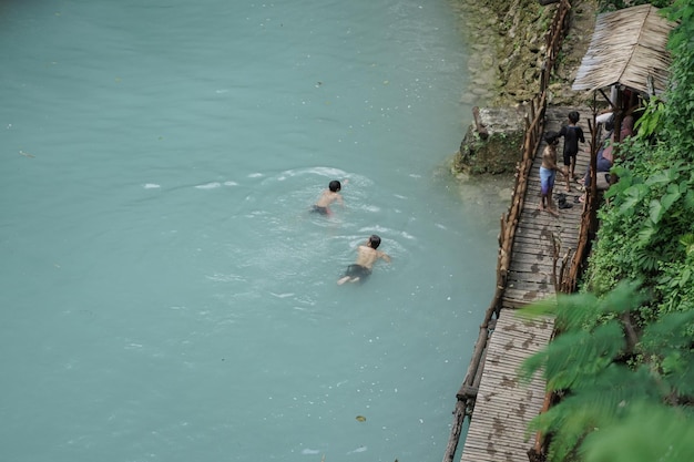 Turisti che si godono una piscina naturale presso la località turistica Kedung Pedut Yogyakarta Indonesia L'unico e fresco fiume è blu