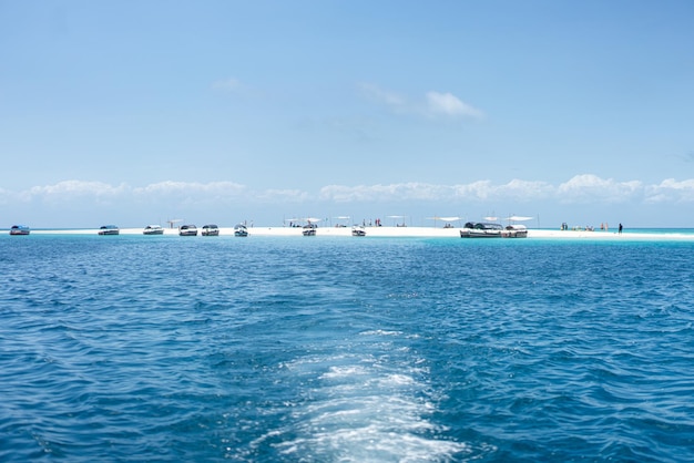 Turisti che si radunano sulla piccola isola tropicale il giorno pieno di sole