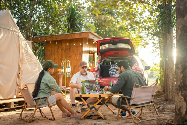 Turisti di gruppo Amici che campeggiano e fanno un barbecue e bevono birra con festa insieme con divertimento e felicità in estate