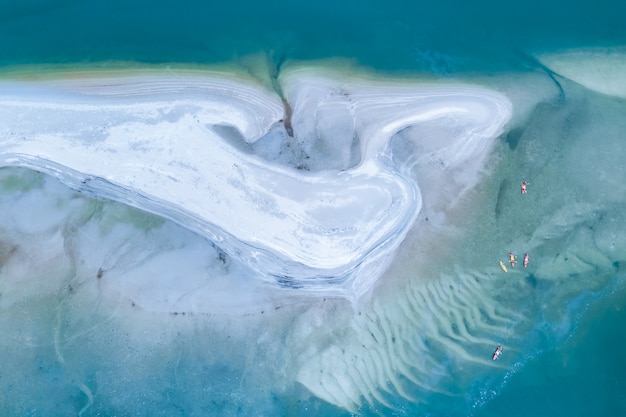 Turisti di kayak sul mare e sulla spiaggia bianca vista dall'alto