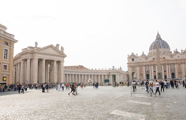 Turisti in Piazza San Pietro, capolavoro architettonico con la cupola di Michelangelo in Vaticano.