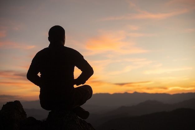 turisti maschi che meditano sulla montagna