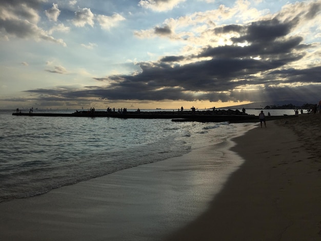 Turisti sulla spiaggia al tramonto