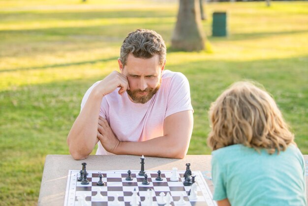 Tutoraggio papà e bambino giocano a giochi di logica padre e figlio che giocano a scacchi al tavolo