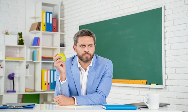 Tutore scolastico serio in aula alla lavagna