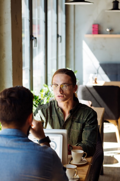 Tutta l'attenzione. Uomo serio e intelligente che guarda il suo collega mentre lo ascolta attentamente