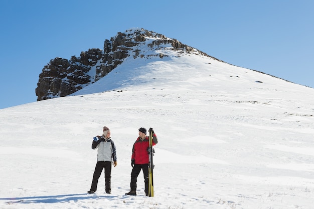 Tutta la lunghezza di una coppia con tavole da sci sulla neve