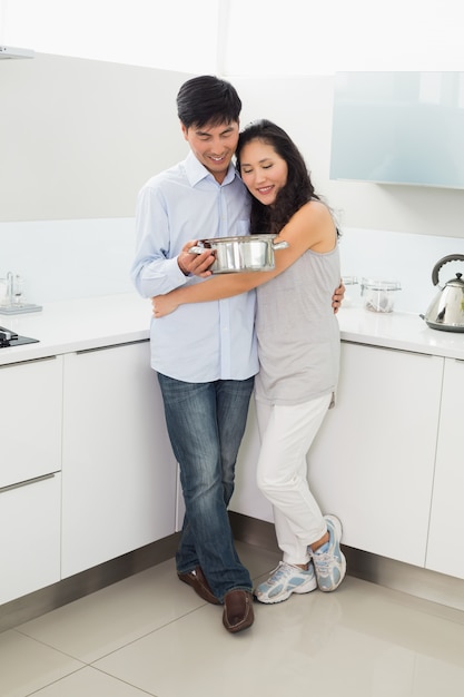 Tutta la lunghezza di una donna che abbraccia l&#39;uomo in cucina