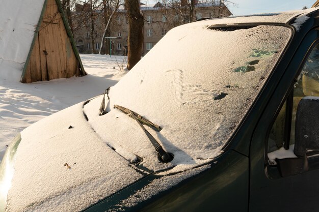 Tutti i finestrini delle auto parcheggiate sono ricoperti di neve e ghiaccio Gelo sul parabrezza nella stagione invernale Grandi gelate e nevicate in città Problemi sulle strade sdrucciolevoli invernali