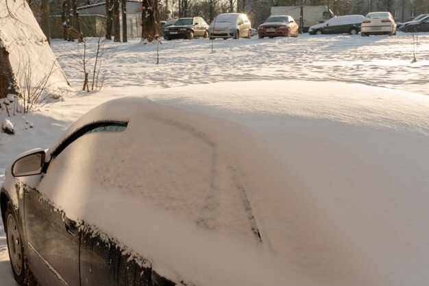 Tutti i finestrini delle auto parcheggiate sono ricoperti di neve e ghiaccio Gelo sul parabrezza nella stagione invernale Grandi gelate e nevicate in città Problemi sulle strade sdrucciolevoli invernali