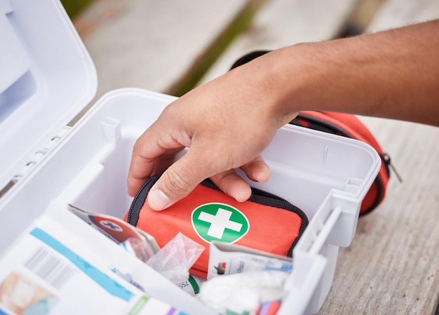 Tutto ciò di cui ha bisogno per curare le tue ferite Inquadratura dall'alto di un paramedico maschio irriconoscibile che guarda nel suo kit di pronto soccorso mentre è in piedi fuori