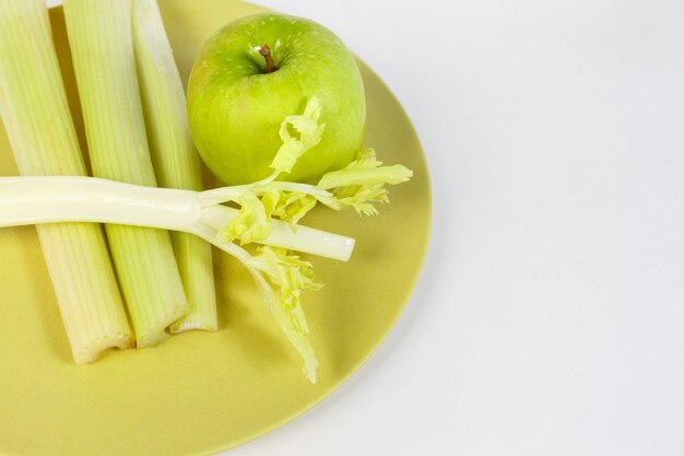 Tutto per il succo fresco: sedano fresco e mela verde su un piatto