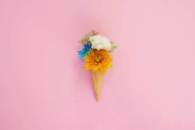 Tutto sembra buono su un cono gelato Colpo di un cono farcito con fiori su uno sfondo colorato