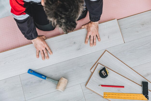 Tuttofare che installa un nuovo pavimento in legno laminato