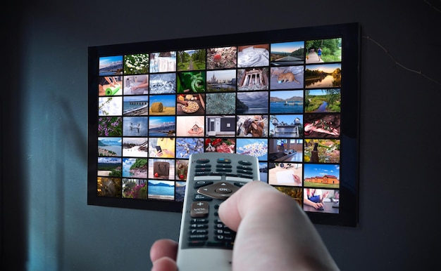 Tv online TV streaming video Media TV on demand Video multimediale online concept su TV in camera oscura Guardare la TV online con telecomando in mano