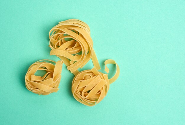 Twisted pasta in fettuccine rotonde nidi su uno spazio verde