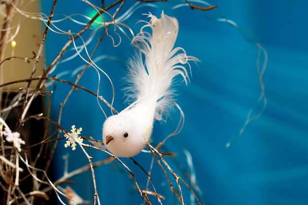 Uccello bianco del giocattolo fatto a mano su un ramo di albero