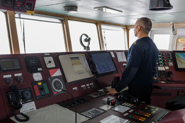 Ufficiale di guardia sul ponte di navigazione uomo caucasico in maglione blu sull'uniforme sul ponte