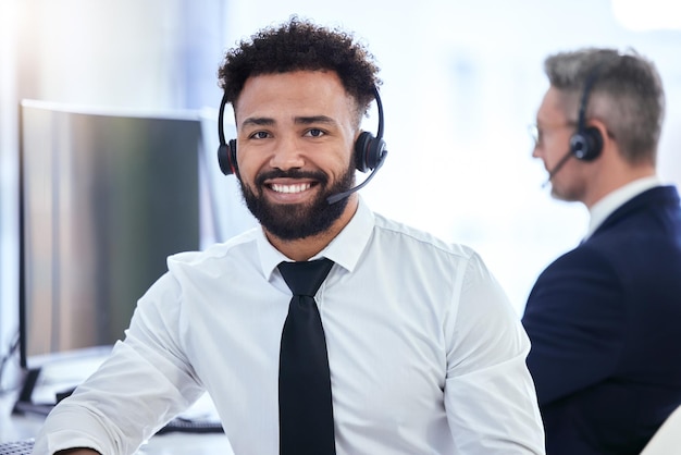 Ufficio del call center e contattaci di un uomo d'affari nell'assistenza clienti con un sorriso felice sul posto di lavoro Ritratto di un impiegato di telemarketing che lavora nel settore della comunicazione al lavoro nella tecnologia