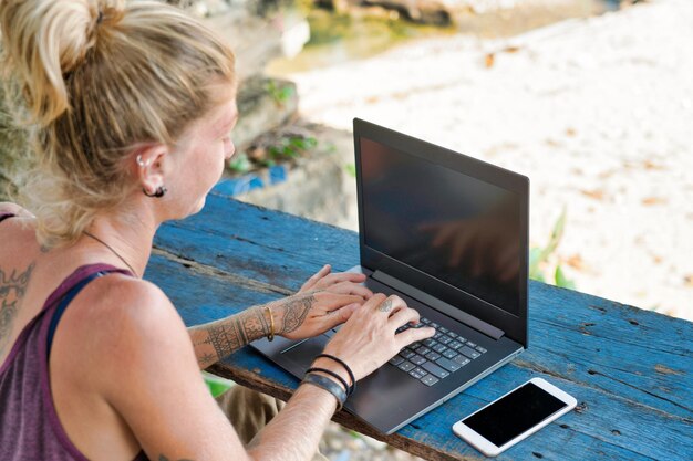 Ufficio di vacanza tropicale all'aperto della donna d'affari nomade digitale