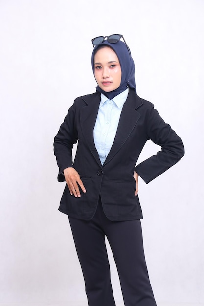 ufficio formale indonesia donna in camicia blu hijab in piedi alla telecamera elegantemente mani sulla vita un
