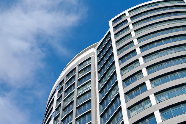 Ufficio grattacielo alto edificio d'affari su sfondo blu cielo guardando fino a un edificio moderno in vetro