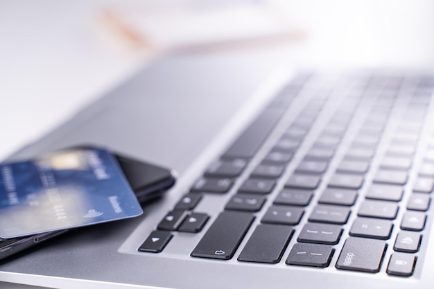 Ufficio pagamento online soggiorno shopping a casa pagamento elettronico con concetto di carta di credito laptop su sfondo bianco tavolo con carrello da vicino