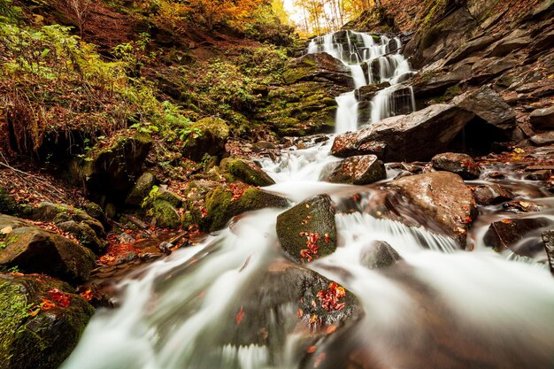 Ukpaine Cascata tra le rocce muschiose Splendido paesaggio rapide su un fiume di montagna nella foresta autunnale nelle montagne dei Carpazi al tramonto Flusso d'argento nel parco nazionale Shypit Carpat Pilipets