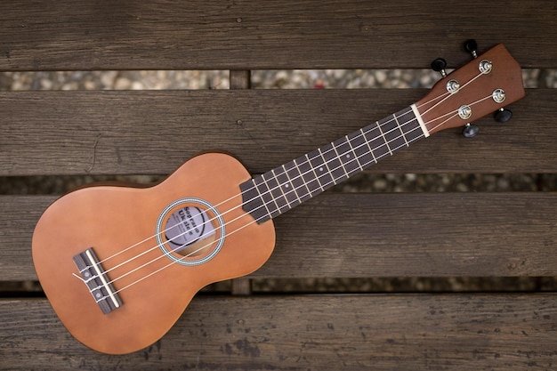 Ukulele estivo con occhiali da sole gialli su una panchina in legno