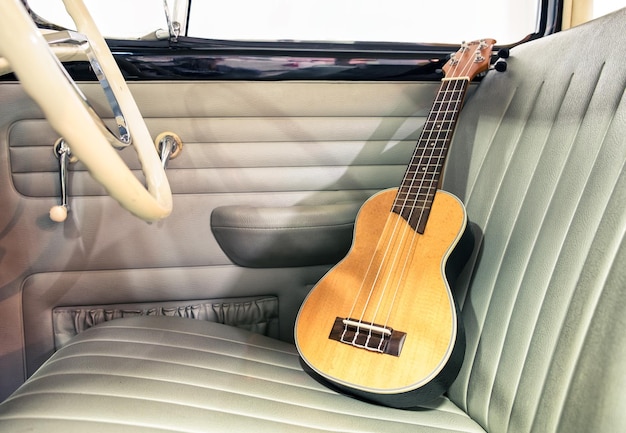 Ukulele in legno sul sedile auto d'epoca