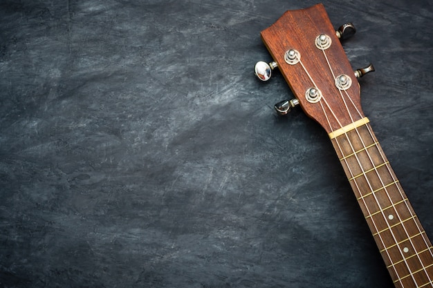 Ukulele su cemento nero. Concetto di strumenti musicali hawaiani e amanti della musica.