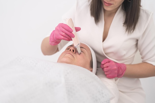 Ultima tecnologia per la cura della pelle Trattamento di pulizia del viso con cavitazione ad ultrasuoni da parte di un professionista
