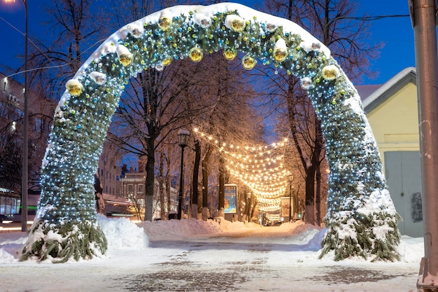 Ulyanovsk Russia 14 febbraio 2022 Enorme arco di Natale in strada nell'illuminazione serale Strada innevata con decorazioni natalizie