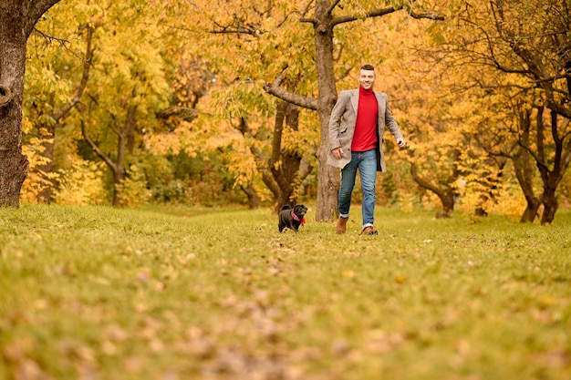 Umore giocoso. Un uomo che gioca con il suo cane nel parco