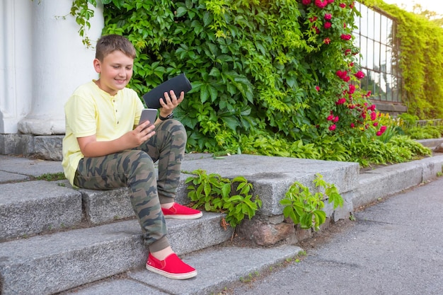 Un adolescente all'aperto con un telefono in mano collega una colonna musicale su bluetooth