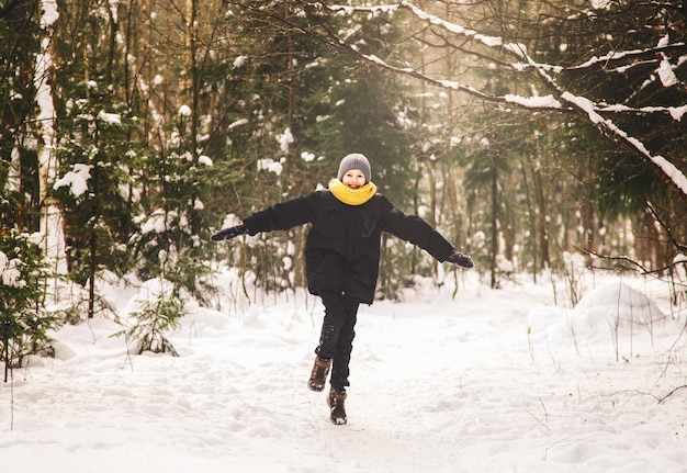 Un adolescente attraversa la foresta invernale.