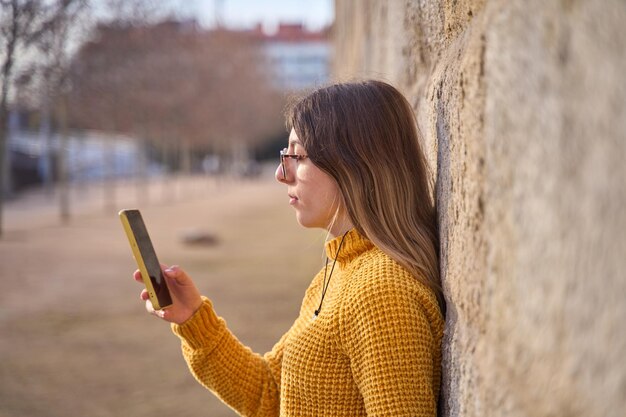 un'adolescente che usa lo smartphone per aggiornare i suoi account sui social media