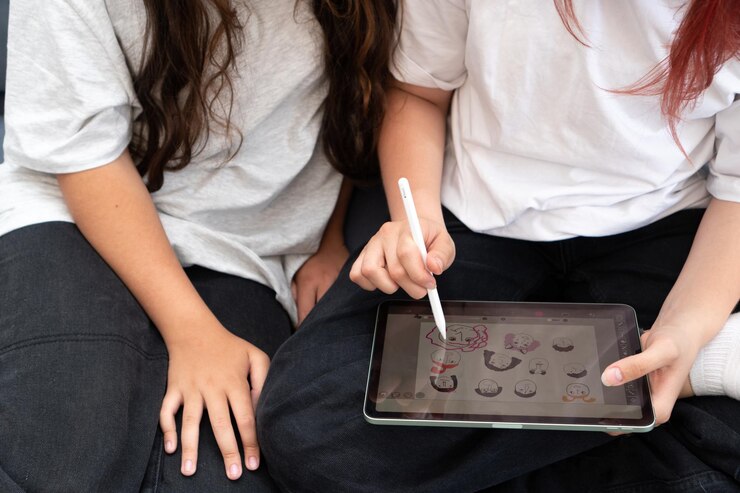Un'adolescente disegna facce buffe con una matita di mela su un tablet di mela durante un corso di formazione online