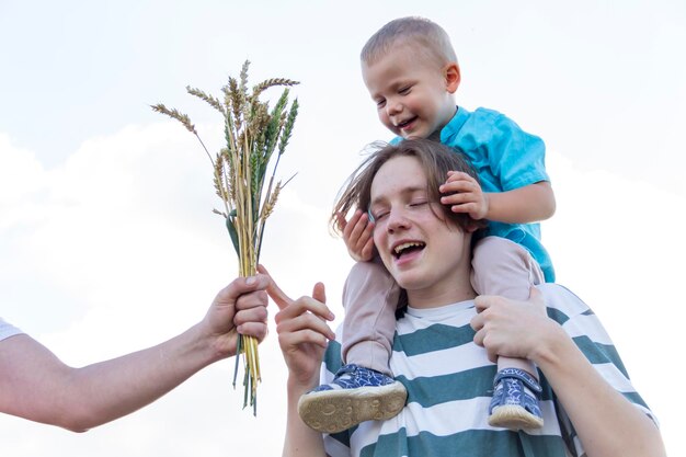 Un adolescente e un bambino camminano spensierati e divertenti in un campo di grano È tempo di raccogliere La crisi alimentare nel mondo