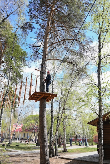 Un'adolescente supera un ostacolo in un parco avventura