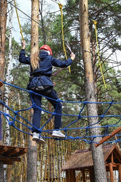 Un'adolescente supera un ostacolo in un parco avventura