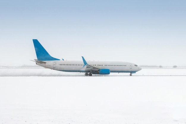 Un aereo a reazione passeggeri si muove sulla pista in una forte bufera di neve