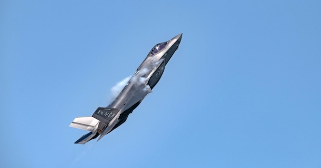 Un aereo a reazione sta volando nel cielo con del fumo che ne esce.