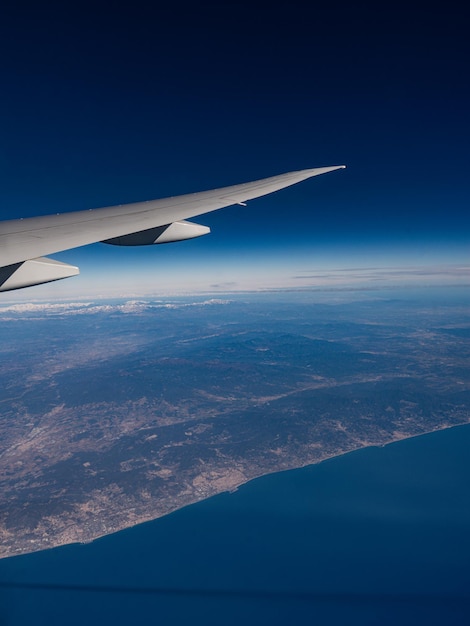 Un aereo sta sorvolando l'oceano e il cielo è blu.