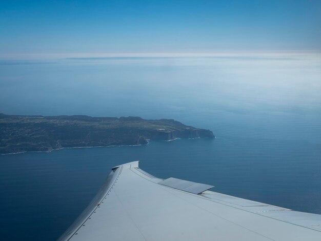 Un aereo sta sorvolando l'oceano e il cielo è blu.