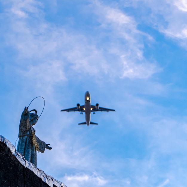 Un aereo sta sorvolando una statua su cui è scritta la parola angelo.