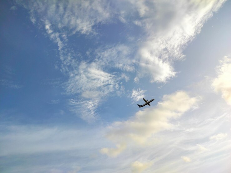 Foto un aereo sta volando nel cielo con le nuvole