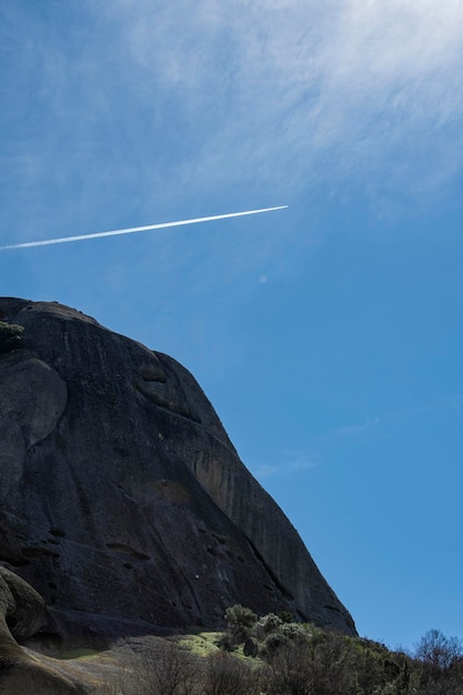 Un aeroplano attraversa il cielo sopra una scogliera a Meteora in Grecia