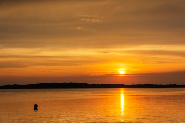 Un affascinante tramonto su un lago forestale in una tranquilla sera d'estate un viaggio sulla superficie dell'acqua