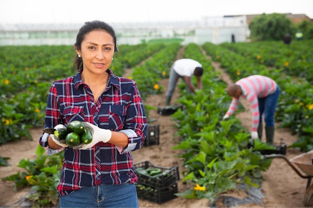 Un'agricoltore colombiana mostra la raccolta di zucchine sul campo della fattoria